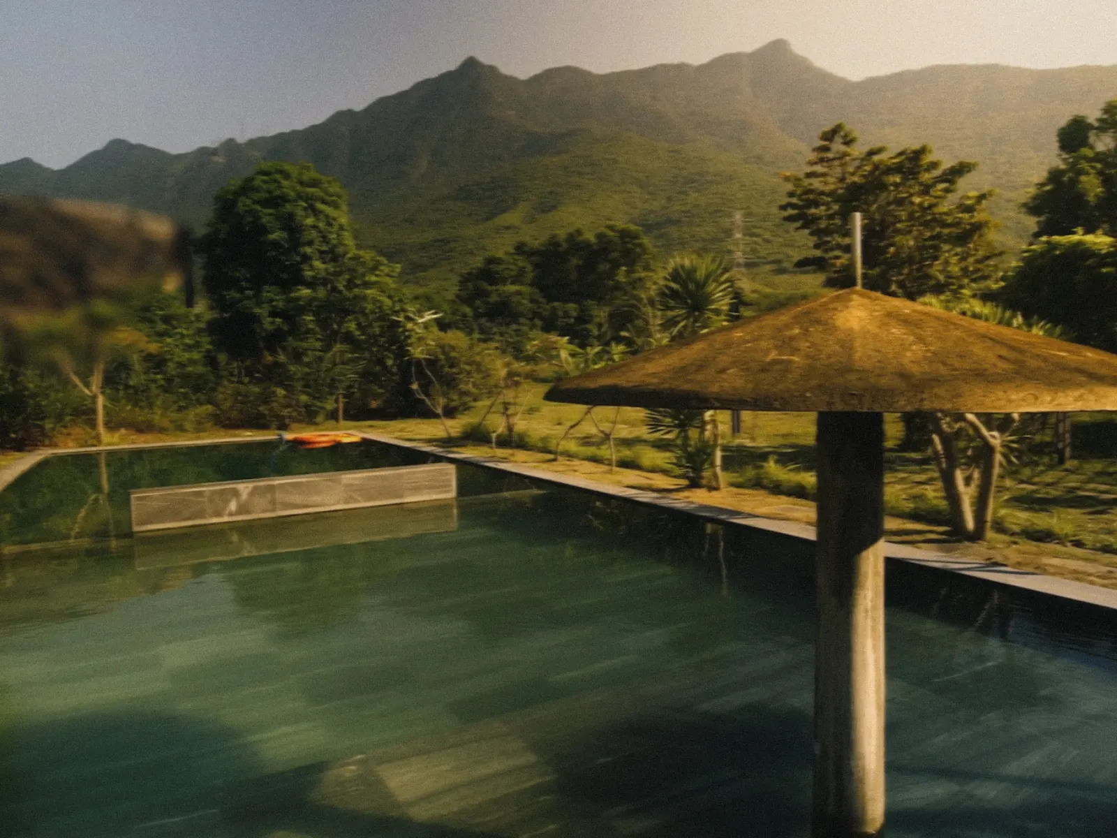 Reflective pool overlooking mountains and tropical greenery